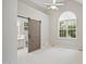 Bright bedroom featuring vaulted ceilings, ensuite bath with sliding barn door, and arched window at 106 Gumdrop Path, Apex, NC 27502
