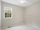 Bright bedroom featuring a ceiling fan, a double hung window, and floating shelves at 106 Gumdrop Path, Apex, NC 27502