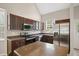 Kitchen with stainless appliances, granite countertops, and dark wood cabinets at 106 Gumdrop Path, Apex, NC 27502