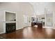 Living room with a fireplace, hardwood floors, vaulted ceiling, and open access to the kitchen at 106 Gumdrop Path, Apex, NC 27502