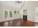Bright Living room with a ceiling fan, fireplace, and French doors to the deck at 106 Gumdrop Path, Apex, NC 27502