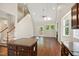Bright living room with dark wood floors, fireplace, and open staircase near the kitchen island at 106 Gumdrop Path, Apex, NC 27502