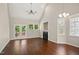Living room with a ceiling fan, fireplace, hardwood floors, and French doors to deck at 106 Gumdrop Path, Apex, NC 27502