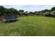 Large backyard features a trampoline, surrounded by greenery and a wooden fence at 1100 Open Field Dr, Garner, NC 27529