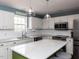 This bright kitchen has stainless steel appliances, white cabinets, and a green island with barstool seating at 1100 Open Field Dr, Garner, NC 27529