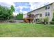 Lush green backyard with mature trees and landscaping, offering a private outdoor retreat with small staircase to deck at 112 Briarfield Dr, Apex, NC 27502