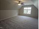 Large bonus room with neutral carpeting, a ceiling fan, and ample natural light from a window at 112 Briarfield Dr, Apex, NC 27502