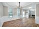 Spacious dining room features a modern chandelier, wood floors, and detailed trim work throughout the room at 112 Briarfield Dr, Apex, NC 27502