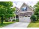 Charming two-story home with stone accents, a two-car garage, and beautifully landscaped front yard at 112 Briarfield Dr, Apex, NC 27502