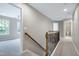 Upstairs hallway with carpet, neutral paint, and wrought iron railing at 112 Briarfield Dr, Apex, NC 27502