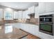 Bright kitchen features stainless steel appliances, double oven, white cabinets, and wooden floors at 112 Briarfield Dr, Apex, NC 27502