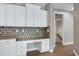 Bright kitchen featuring a built-in desk area with granite counters and stylish geometric tile backsplash at 112 Briarfield Dr, Apex, NC 27502