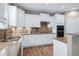 Kitchen with stainless steel appliances, gas stove, white cabinets, tile backsplash and wood floors at 112 Briarfield Dr, Apex, NC 27502