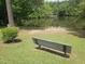 A tranquil community lake with a bench overlooking the water and surrounding trees at 112 Briarfield Dr, Apex, NC 27502