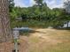 A serene community lake surrounded by lush greenery and mature trees at 112 Briarfield Dr, Apex, NC 27502