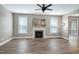Bright living room featuring wood floors, fireplace, ceiling fan and plentiful natural light at 112 Briarfield Dr, Apex, NC 27502