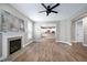 Open-concept living room showcasing a fireplace, ceiling fan, wood floors, and entrance to kitchen at 112 Briarfield Dr, Apex, NC 27502