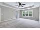 Spacious main bedroom with tray ceiling, fan, and large window at 112 Briarfield Dr, Apex, NC 27502