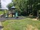 Community playground with green slides and a climbing structure, set in a lush, green, treed area at 112 Briarfield Dr, Apex, NC 27502