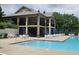 A stunning community pool and clubhouse surrounded by chairs and tables with umbrellas at 112 Briarfield Dr, Apex, NC 27502