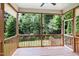 A covered porch provides a view of lush greenery and a private outdoor living space with wooden decking at 112 Briarfield Dr, Apex, NC 27502