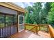 Screened-in deck with wooden railing, providing a comfortable outdoor space with privacy and protection from insects at 112 Briarfield Dr, Apex, NC 27502