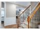 Carpeted staircase features wood railing with iron spindles, and wainscoting along the wall up the stairs at 112 Briarfield Dr, Apex, NC 27502