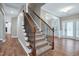A carpeted staircase with dark wood banister leads to the upper levels of the house, combining beauty and safety at 112 Briarfield Dr, Apex, NC 27502