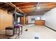 Unfinished basement with exposed ceiling and tiled floors and wood paneled walls at 1219 Lakeland St, Durham, NC 27701