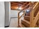 Wooden stairs leading to an unfinished basement with exposed ceiling joists at 1219 Lakeland St, Durham, NC 27701