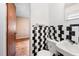 Retro bathroom with black and white checkered tiling, a sink, and toilet at 1219 Lakeland St, Durham, NC 27701