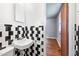 Bathroom with black and white tiling featuring a sink and a view into the next room at 1219 Lakeland St, Durham, NC 27701