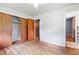 Bedroom with hardwood floors and an ample-sized closet with wooden doors at 1219 Lakeland St, Durham, NC 27701