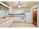Well-lit kitchen featuring white cabinets, a standard stove, and a side-by-side refrigerator at 1219 Lakeland St, Durham, NC 27701