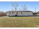 Expansive backyard featuring a well-maintained lawn, mature trees, and a painted brick building exterior at 1246 Nc-27, Benson, NC 27504