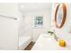 Bright bathroom featuring a marble-tiled shower and a modern sink with a wood trimmed mirror at 1246 Nc-27, Benson, NC 27504