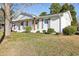 White brick one-story home with green lawn, gray shutters and front wooden porch columns at 1246 Nc-27, Benson, NC 27504