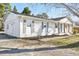 White brick one-story home with green lawn, gray shutters and front wooden porch columns at 1246 Nc-27, Benson, NC 27504