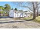 White brick one-story home with green lawn, gray shutters and front wooden porch columns at 1246 Nc-27, Benson, NC 27504