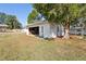 Exterior view of detached garage with ample parking space, mature trees, and sunny skies at 1246 Nc-27, Benson, NC 27504
