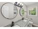 Bright bathroom featuring a double vanity with granite countertop and two mirrors at 132 Edgewood Dr, Louisburg, NC 27549