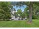 Attractive white brick home with manicured lawn and trees providing natural shade and curb appeal at 132 Edgewood Dr, Louisburg, NC 27549