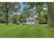 Beautifully landscaped white brick home with a well-manicured lawn and mature trees offering privacy at 132 Edgewood Dr, Louisburg, NC 27549