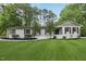 Charming white brick home with black shutters and a beautifully landscaped front yard and mature trees at 132 Edgewood Dr, Louisburg, NC 27549