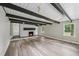 Spacious living room features a white brick fireplace, dark wood ceiling beams, and hardwood floors at 132 Edgewood Dr, Louisburg, NC 27549
