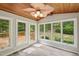 Bright sunroom with wood ceiling, fan, and large windows overlooking the backyard at 132 Edgewood Dr, Louisburg, NC 27549