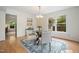 Cozy dining room features a glass table with seating for four, bathed in natural light from the large windows at 1600 Budwood Dr, Raleigh, NC 27609