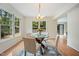 Bright dining room features a glass table, stylish chandelier, and a large windows with a view of lush greenery at 1600 Budwood Dr, Raleigh, NC 27609