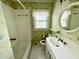Bathroom featuring floral wallpaper, an oval mirror, and a vanity with a white sink at 1609 Cypress Dr, Henderson, NC 27536