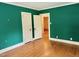 View of the bedroom with white doors and trim, and hardwood floors at 1609 Cypress Dr, Henderson, NC 27536